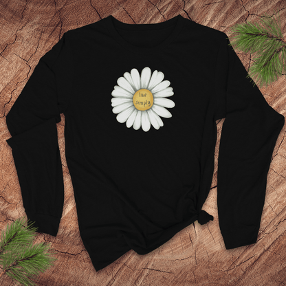 Black long-sleeve tshirt with a white daisy and 'live simply' text on a wooden surface