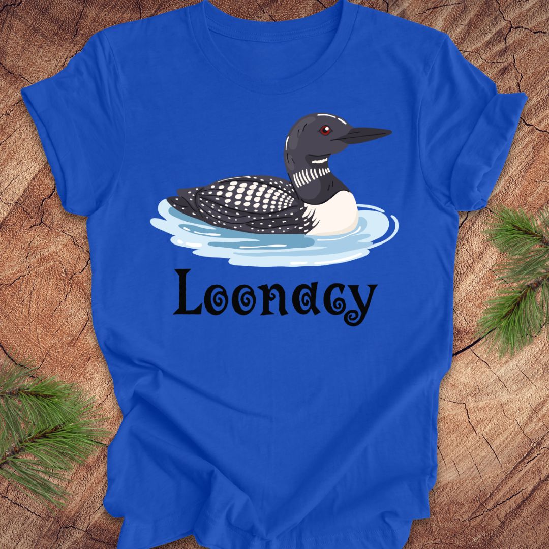 Blue t-shirt with a loon graphic and 'Loonacy' text on a wooden surface.