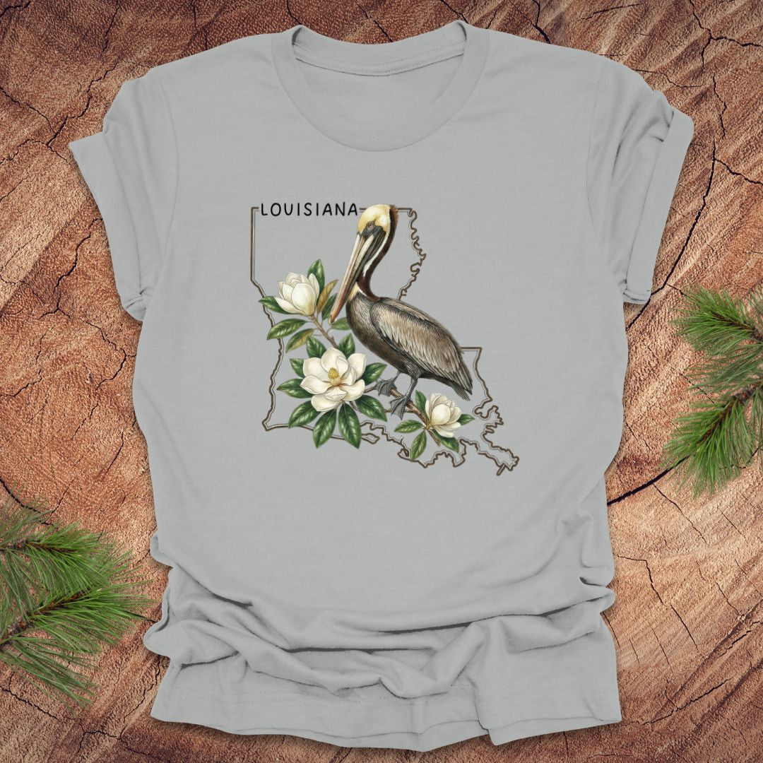 Gray t-shirt with Louisiana-themed design featuring a pelican and magnolias on a wooden surface.