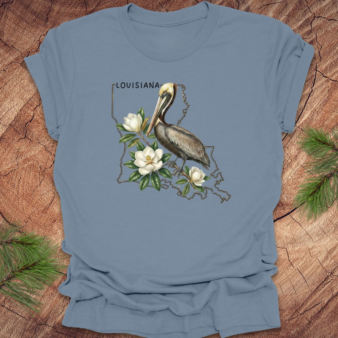 Blue t-shirt with a pelican and magnolia design on a wooden surface