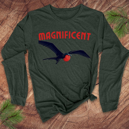 Green long-sleeve shirt with a frigatebird graphic and 'MAGNIFICENT' text on a wooden surface.