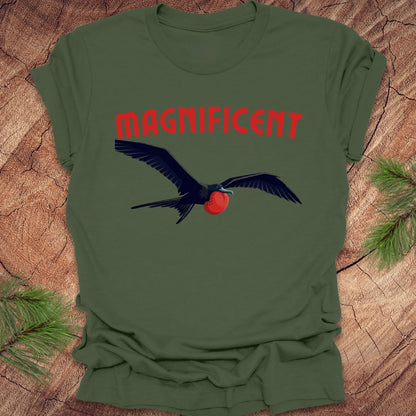 Green t-shirt with a bird graphic and 'MAGNIFICENT' text on a wooden surface.