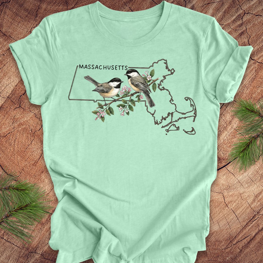 Mint green t-shirt with Massachusetts map and birds design on a wooden surface