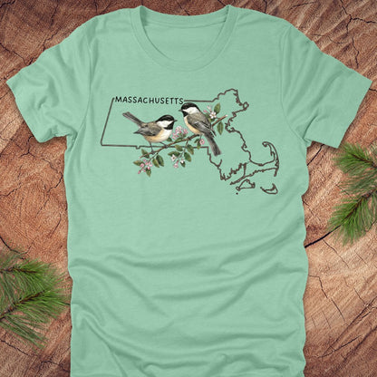 Mint green t-shirt with Massachusetts map and chickadee design on a wooden surface