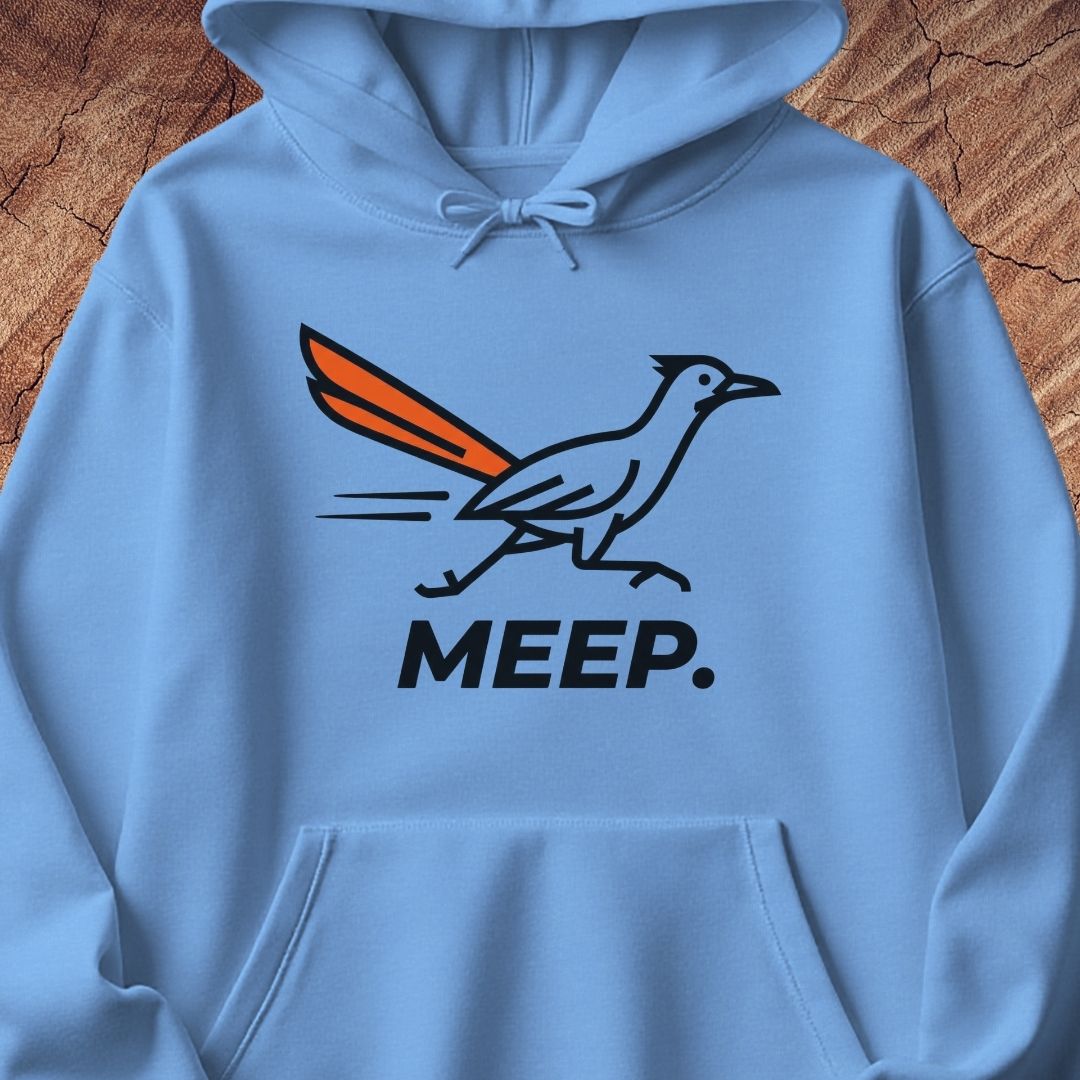 A light blue pullover hoodie featuring a graphic of a roadrunner with an orange tail and the word 'MEEP.' printed below in black, displayed against a rustic wood background.