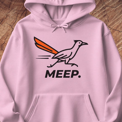A light pink pullover hoodie featuring a graphic of a roadrunner with an orange tail and the word 'MEEP.' printed below in black, displayed against a rustic wood background.
