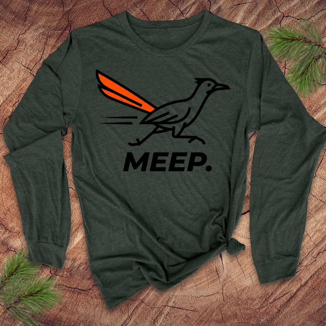 Green long-sleeve shirt with a graphic of a roadrunner and 'MEEP.' text on a wooden surface.