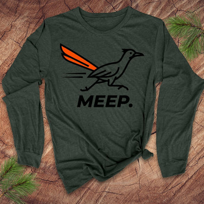 Green long-sleeve shirt with a graphic of a roadrunner and 'MEEP.' text on a wooden surface.