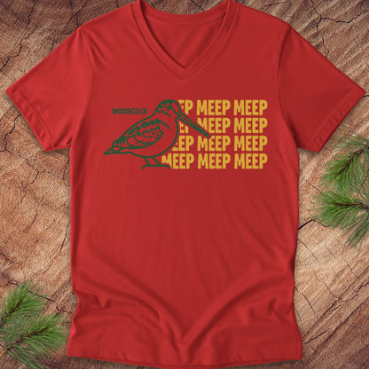 Red v-neck t-shirt with a woodcock graphic and 'MEEP MEEP' text on a wooden surface