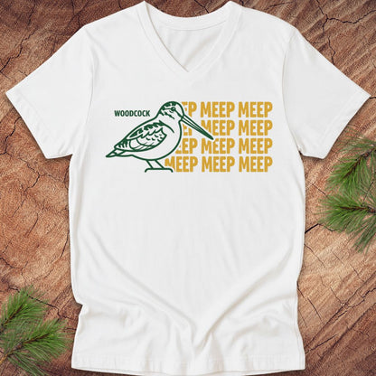 White v-neck t-shirt with a woodcock graphic and text on a wooden surface