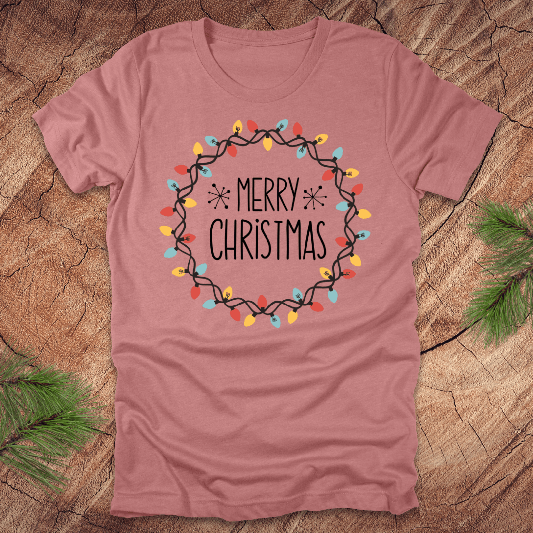 Mauve t-shirt with 'Merry Christmas' design on a wooden surface