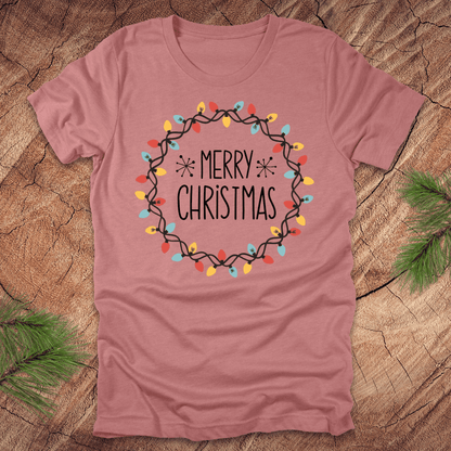 Mauve t-shirt with 'Merry Christmas' design on a wooden surface