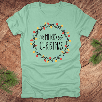 Mint green t-shirt with 'Merry Christmas' design on a wooden surface
