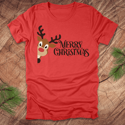 Red t-shirt with a reindeer peeking out from the side and 'Merry Christmas' text on a wooden surface.