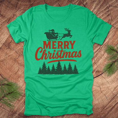 Green t-shirt with 'Merry Christmas' design featuring Santa and reindeer on a wooden surface.