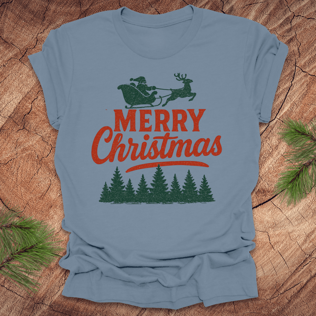Steel Blue t-shirt with 'Merry Christmas' design on a wooden surface with pine branches.