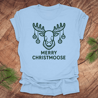 Light blue t-shirt with a moose graphic and 'Merry Christmoose' text on a wooden surface.