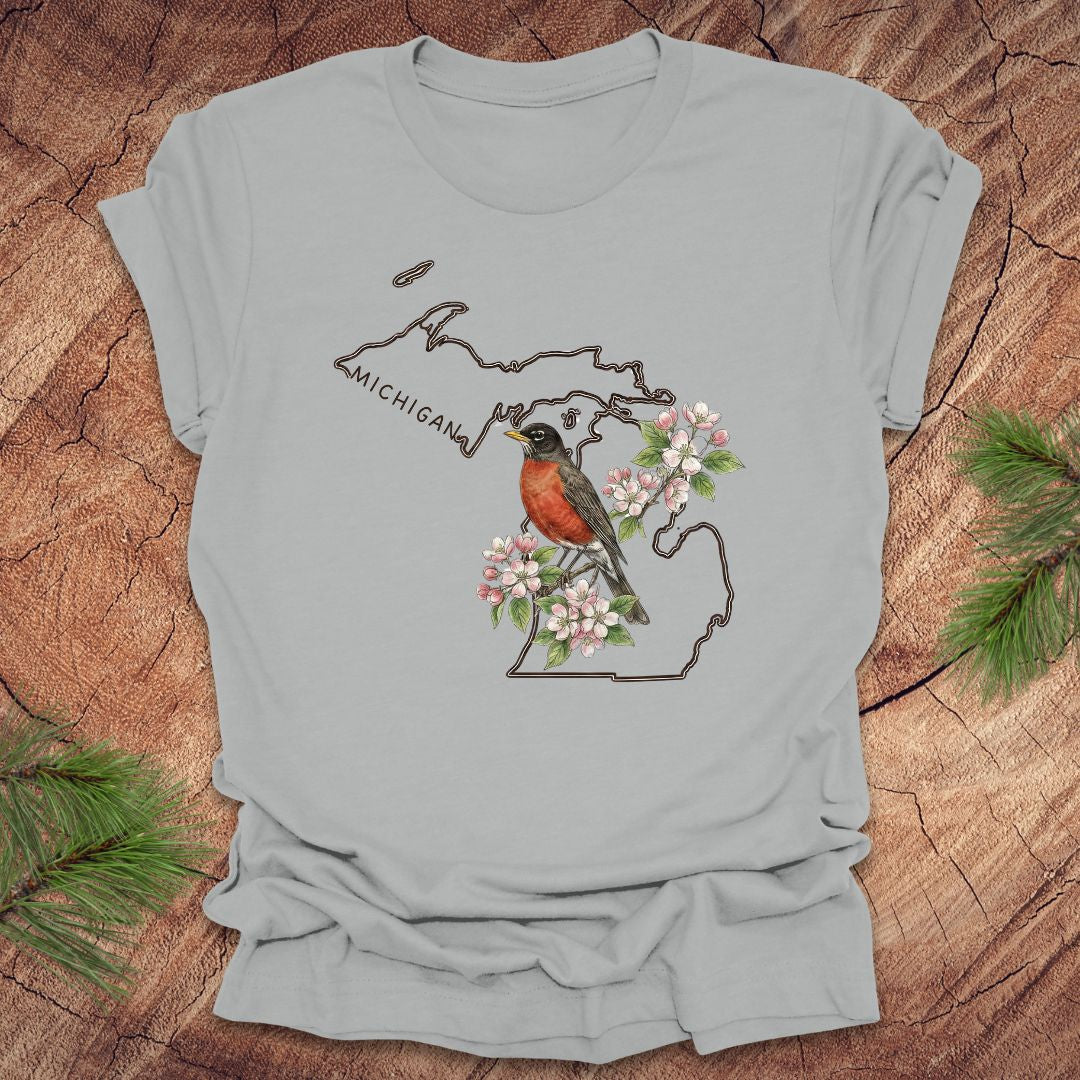 Silver t-shirt with Michigan-themed design featuring a robin and apple blossom on a wooden surface.