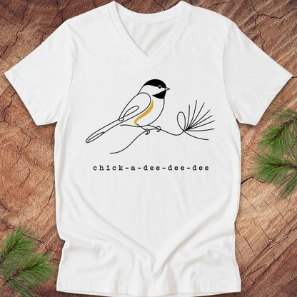White t-shirt with a chickadee design and 'chick-a-dee-dee-dee' text on a wooden surface.