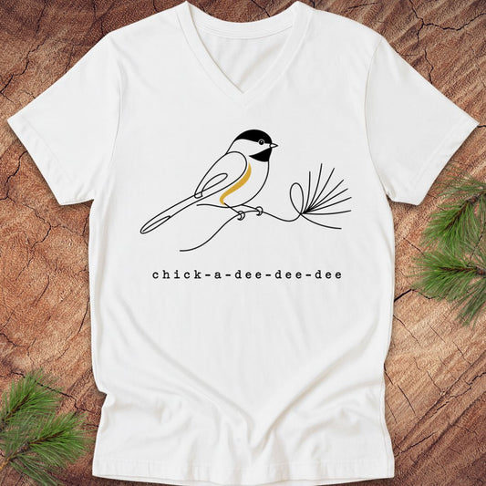 White t-shirt with a chickadee design and 'chick-a-dee-dee-dee' text on a wooden surface.