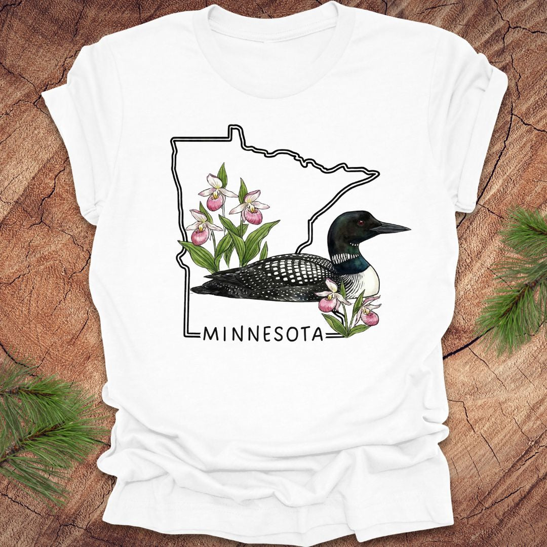 White t-shirt with Minnesota state outline and loon design on a wooden surface