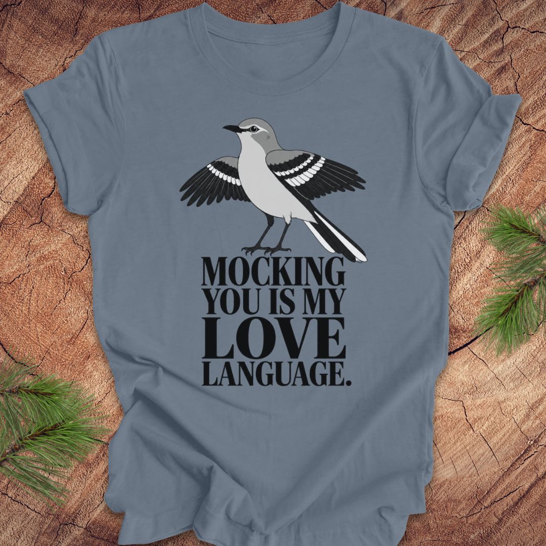 A slate blue crewneck t-shirt featuring a printed graphic of a gray and black mocking bird with the text 'MOCKING YOU IS MY LOVE LANGUAGE.' in black.