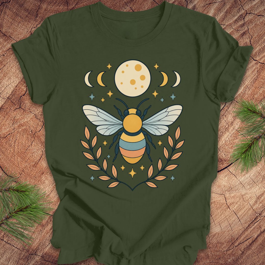 Green t-shirt with a bee and moon design on a wooden surface
