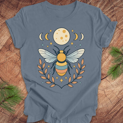 Blue t-shirt with a bee and moon design on a wooden surface