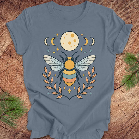 Blue t-shirt with a bee and moon design on a wooden surface