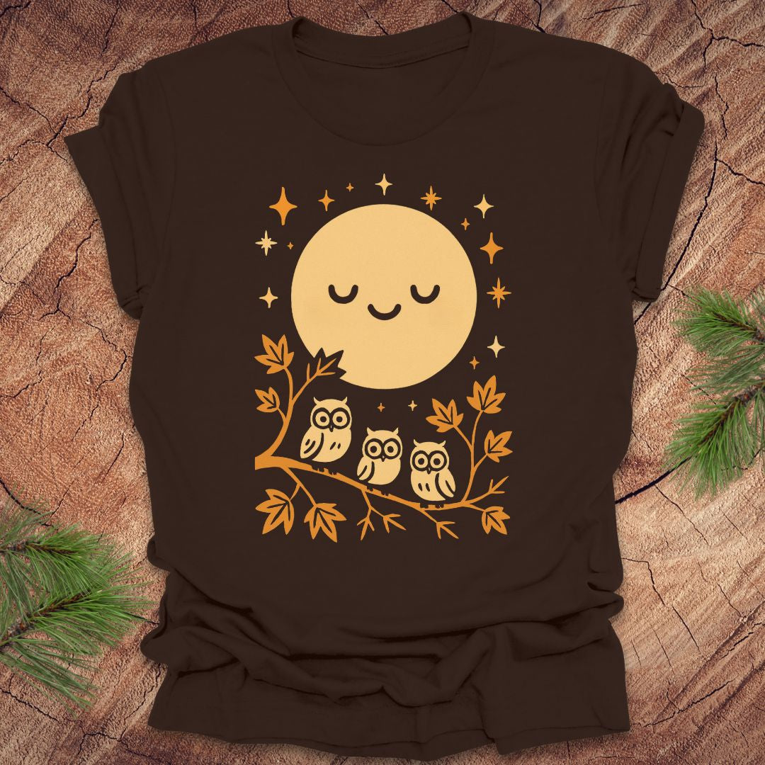 Brown t-shirt with a yellow moon and owl design on a wooden surface
