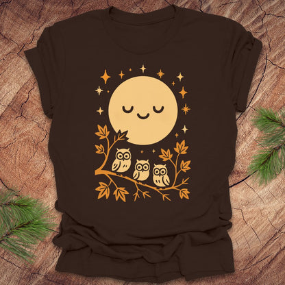 Brown t-shirt with a yellow moon and owl design on a wooden surface