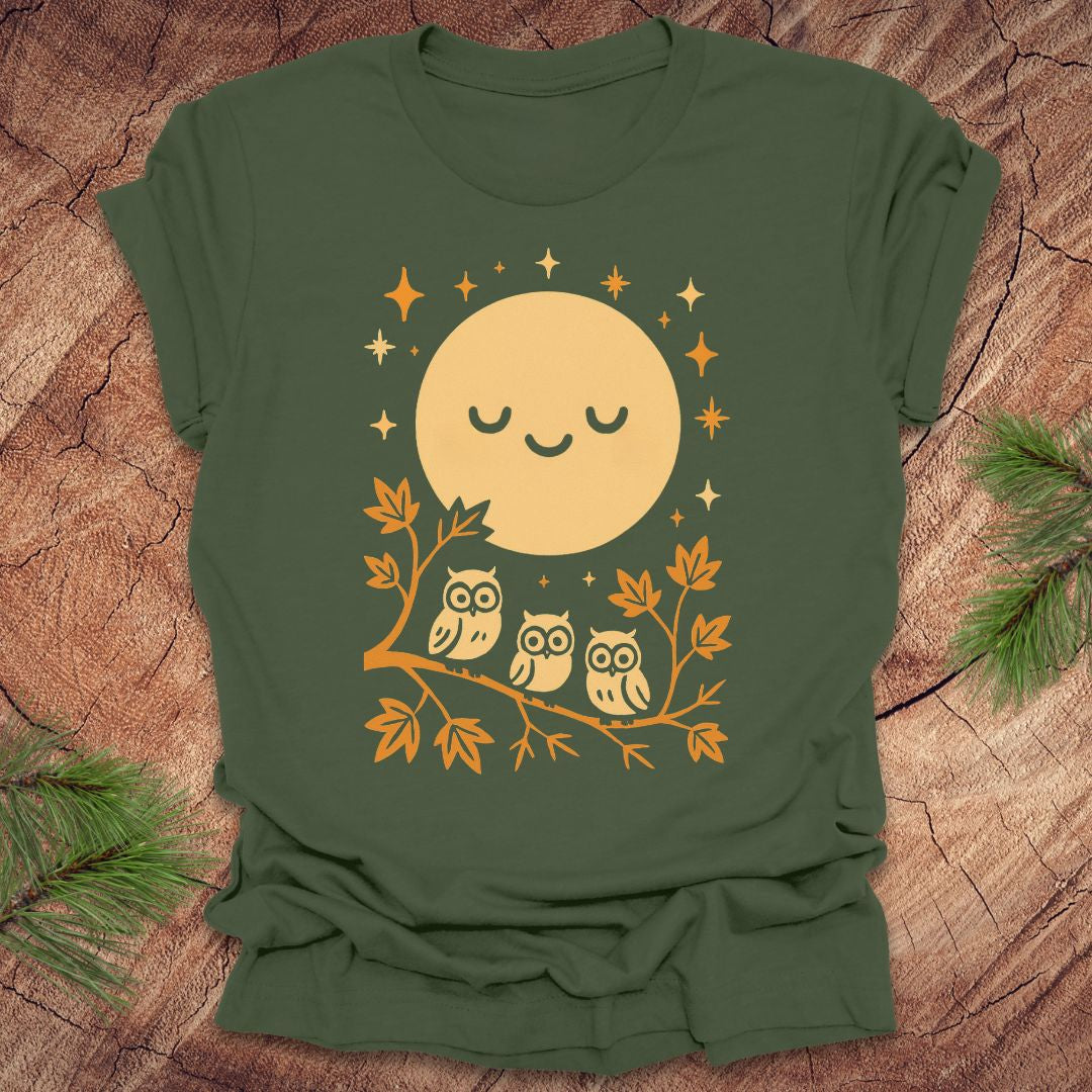 Green t-shirt with a yellow moon and owl design on a wooden surface