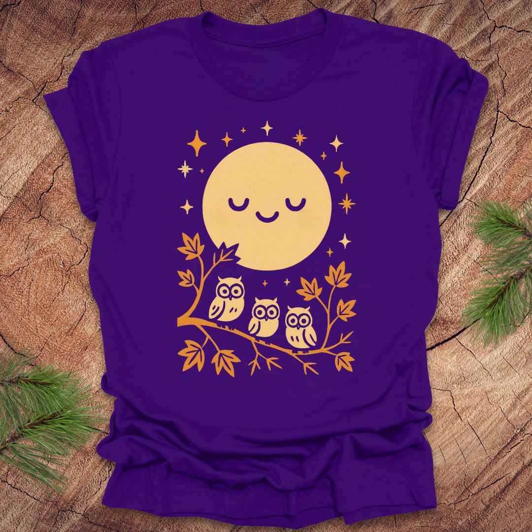 Purple t-shirt with a yellow moon and owl design on a wooden surface