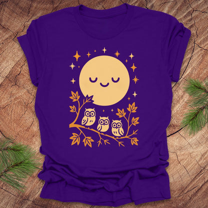 Purple t-shirt with a yellow moon and owl design on a wooden surface