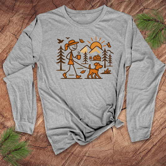 Gray long-sleeve shirt with a graphic design of a person walking a dog in a forest on a wooden surface.