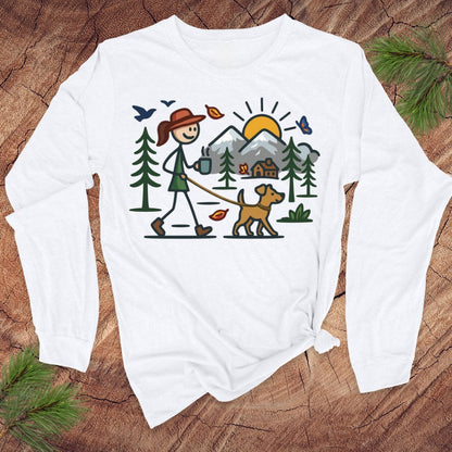White long-sleeve shirt with a colorful graphic of a person walking a dog in the woods on a wooden surface.