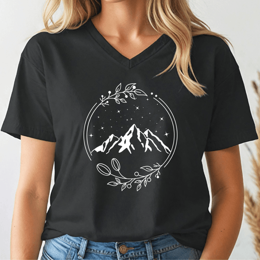 Person wearing a black t-shirt with a mountain design on a plain background
