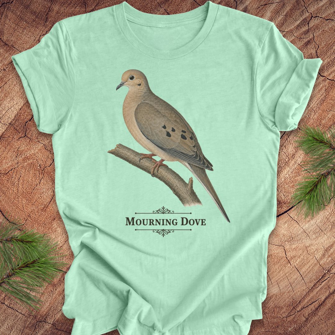 Mint green t-shirt with a mourning dove bird and text on a wood background.