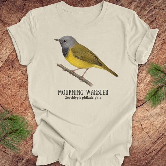 Beige t-shirt with a mourning warbler illustration and text on a wooden surface