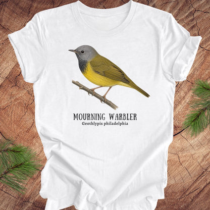 White t-shirt with a mourning warbler illustration and text on a wooden surface