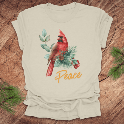 Beige t-shirt with a red cardinal and 'Peace' text on a wooden surface