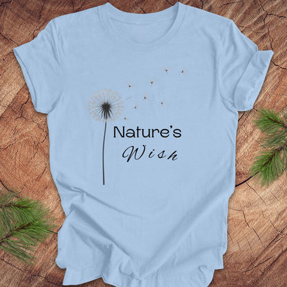 Light blue t-shirt with 'Nature's Wish' text and dandelion graphic on a wooden surface.