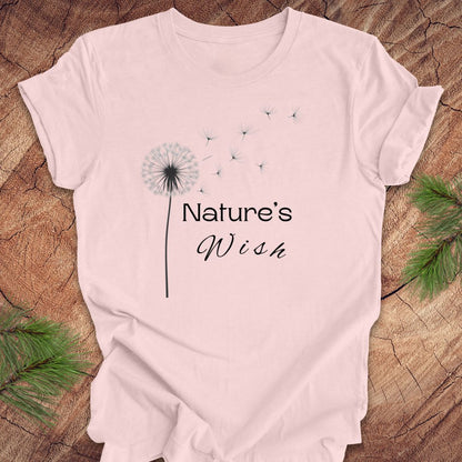 Pink t-shirt with 'Nature's Wish' design on a wooden surface