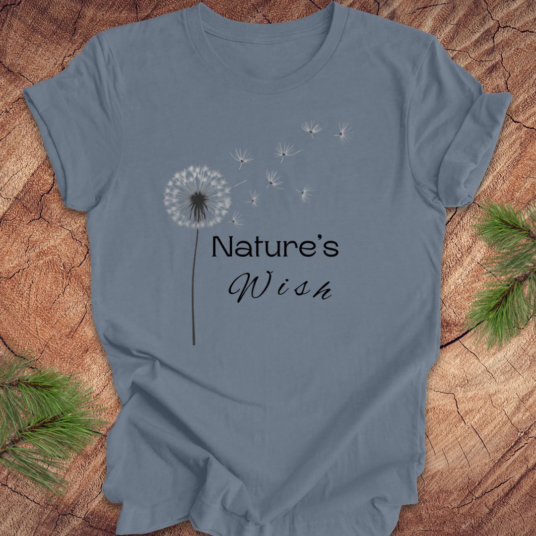 Blue t-shirt with 'Nature's Wish' text and dandelion graphic on a wooden surface.