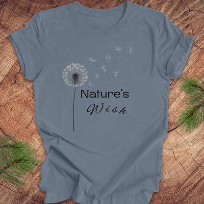 Blue t-shirt with 'Nature's Wish' text and dandelion graphic on a wooden surface.