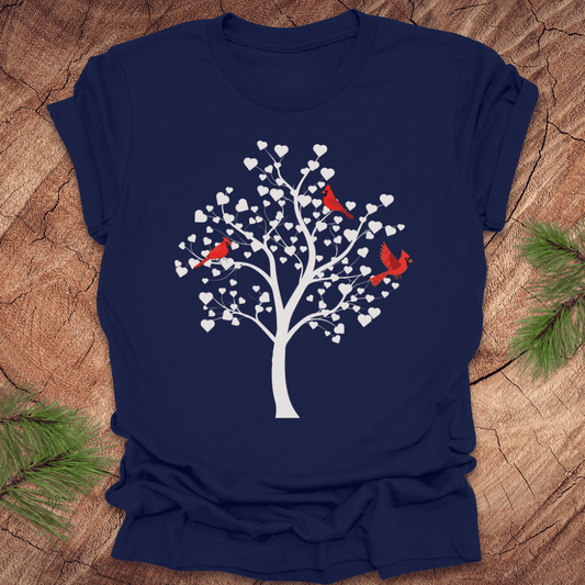 Navy blue t-shirt with a tree design featuring cardinals and white hearts on a wooden surface.