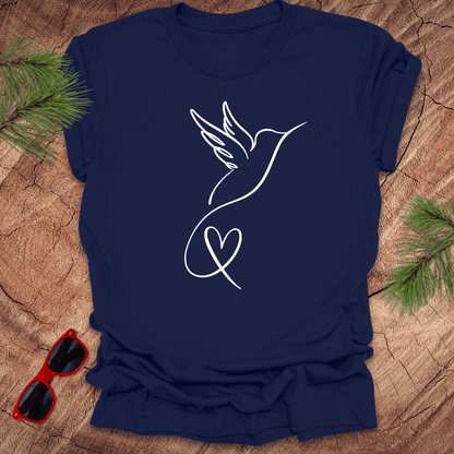 Navy blue t-shirt with a hummingbird and heart design on a wooden surface with sunglasses and greenery.
