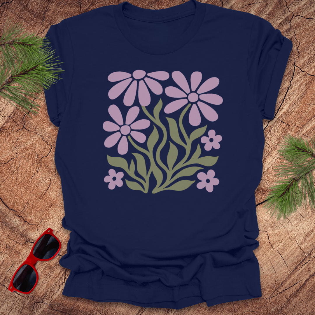 Navy blue t-shirt with floral design on a wooden surface with sunglasses and greenery.