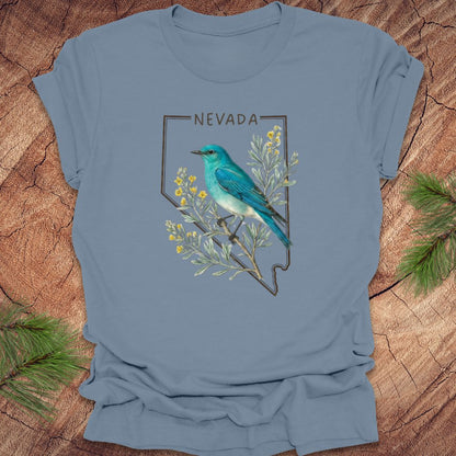 Steel blue t-shirt with Nevada state design featuring a mountain bluebird and sagebrush on a wooden surface.