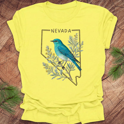 Yellow t-shirt with a blue bird and 'Nevada' design on a wooden surface.